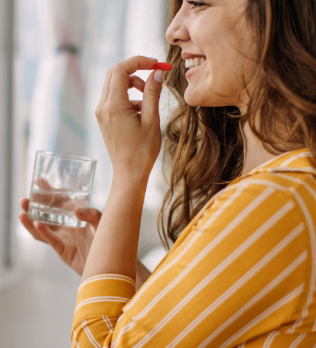 Mujer feliz tomando suplementos nutricionales